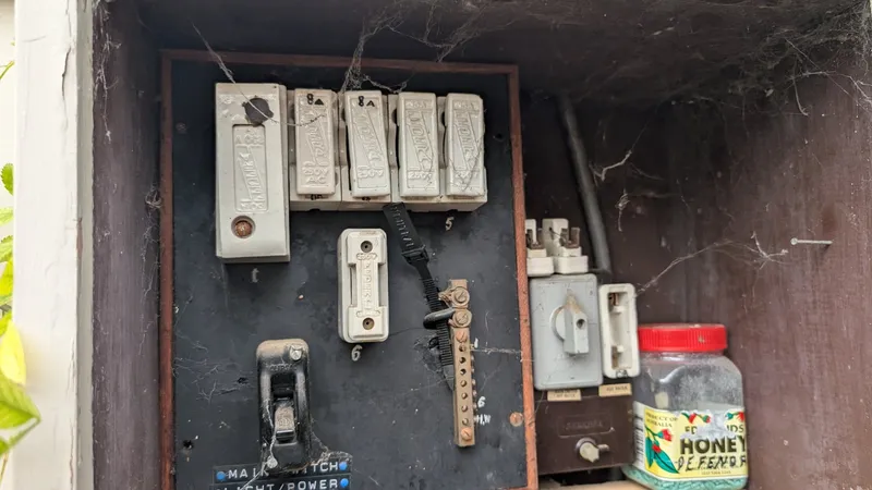 Old ceramic rewirable fuses in a timber meter box at a Belmont home, before a switchboard upgrade by LJ Electrical Group